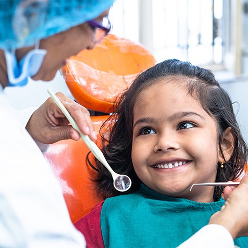 A child smiling at her dentist