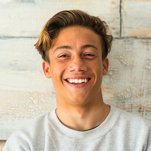 Male teenager smiling after visiting Anthem BlueCross BlueShield dentist in Worcester