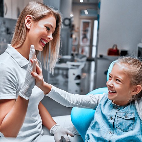 Young girl giving a high five to dentist