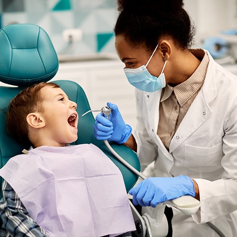 Child smiling at dentist during cleaning
