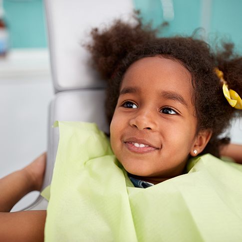 Child smiling while relaxing on treatment chair