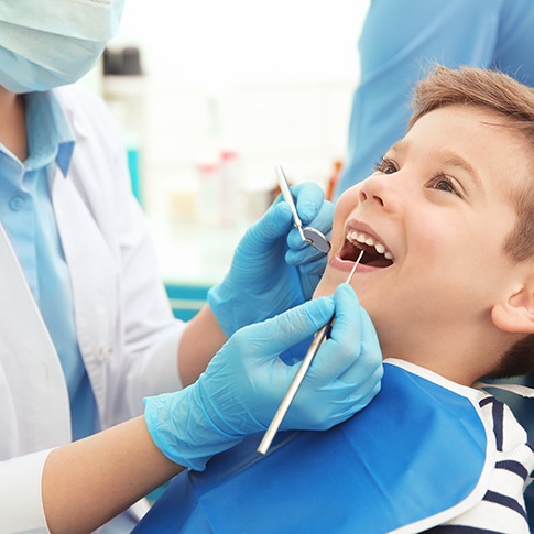 Dentist examining smiling patient's teeth
