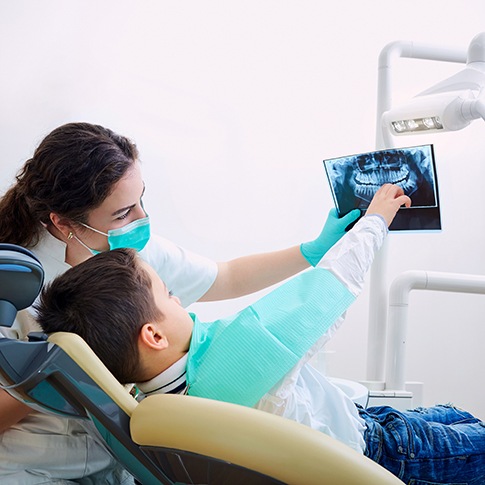 Dentist and child looking at X-rays