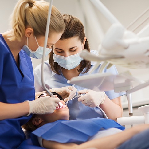 Dentist and assistant working on child's tooth