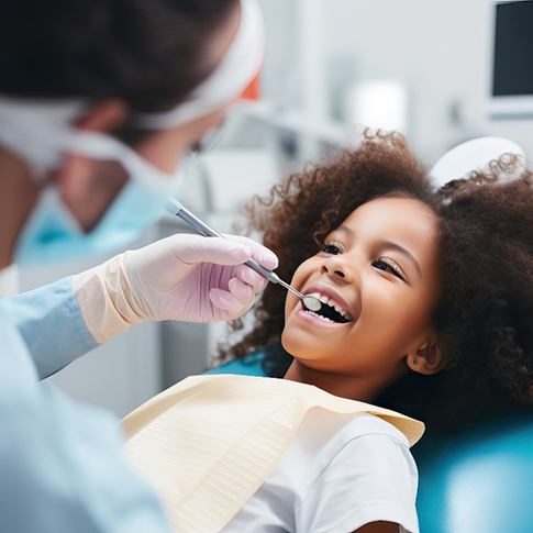 Young girl smiling at dentist during checkup