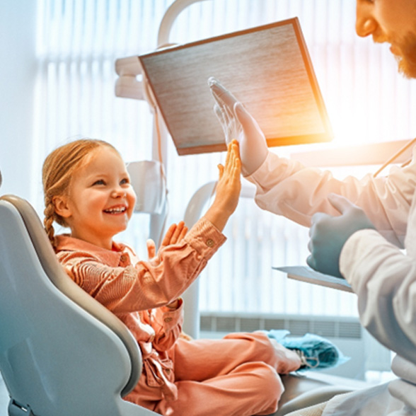 Little girl giving her Delta Dental pediatric dentist in Worcester a high-five 