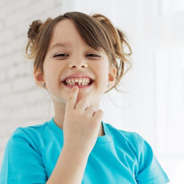 a child with a missing tooth smiling