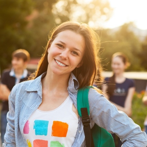 Young woman sharing healthy smile after dentistry for teens