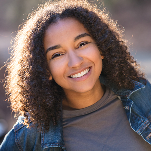 Young woman with healthy smile after visiting her pediatric dentist in Worcester Massachusetts