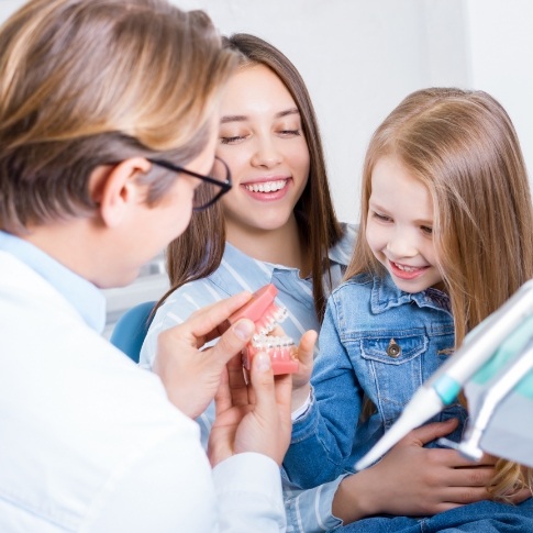 Dentist pediatric dental patient and parent discussing dental insurance