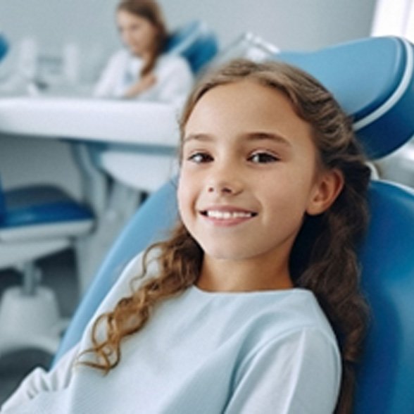 Closeup of young girl smiling while sitting in dental chair