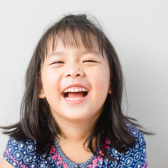 Young girl in blue dress smiling