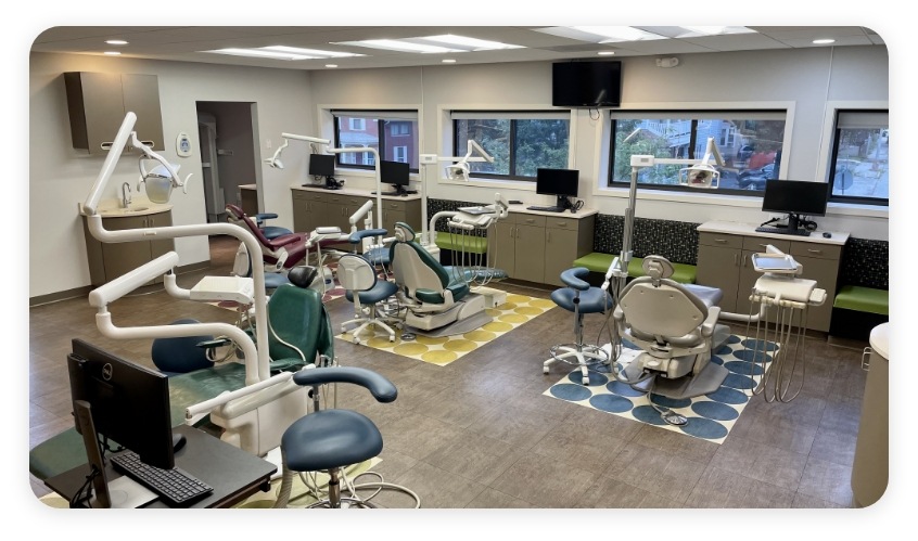 Large room with rows of dental treatment chairs