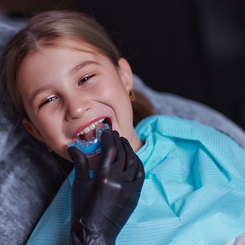 a teen receiving an athletic mouthguard