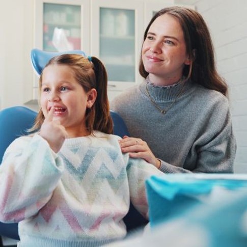 Child and her mother interacting with dentist