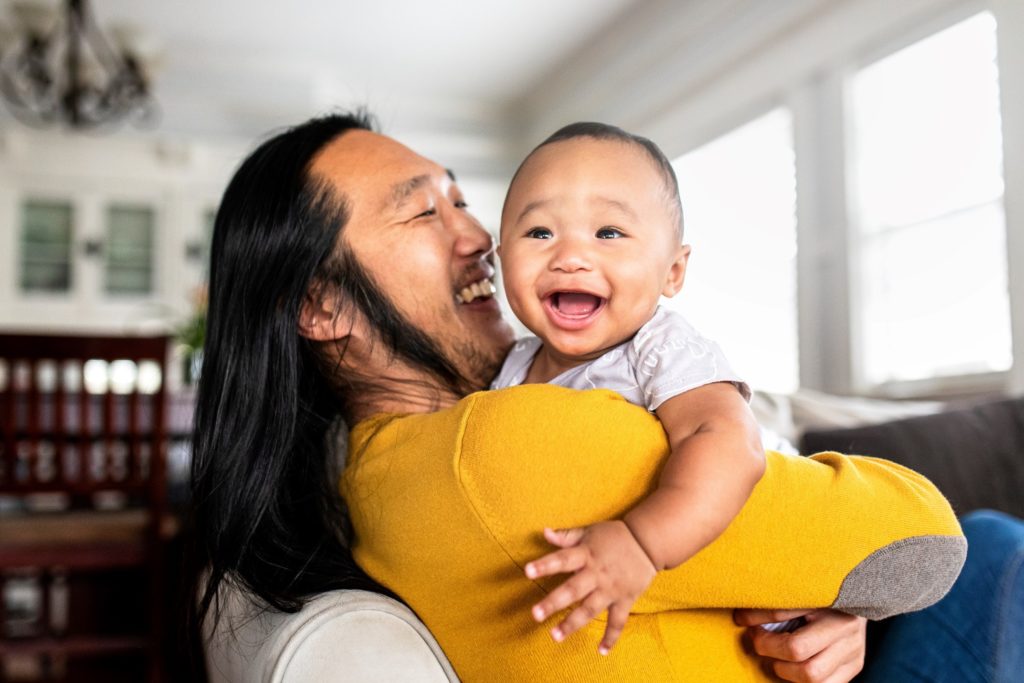 Parent and infant smiling at home