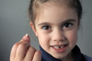 a child holding their knocked-out tooth 