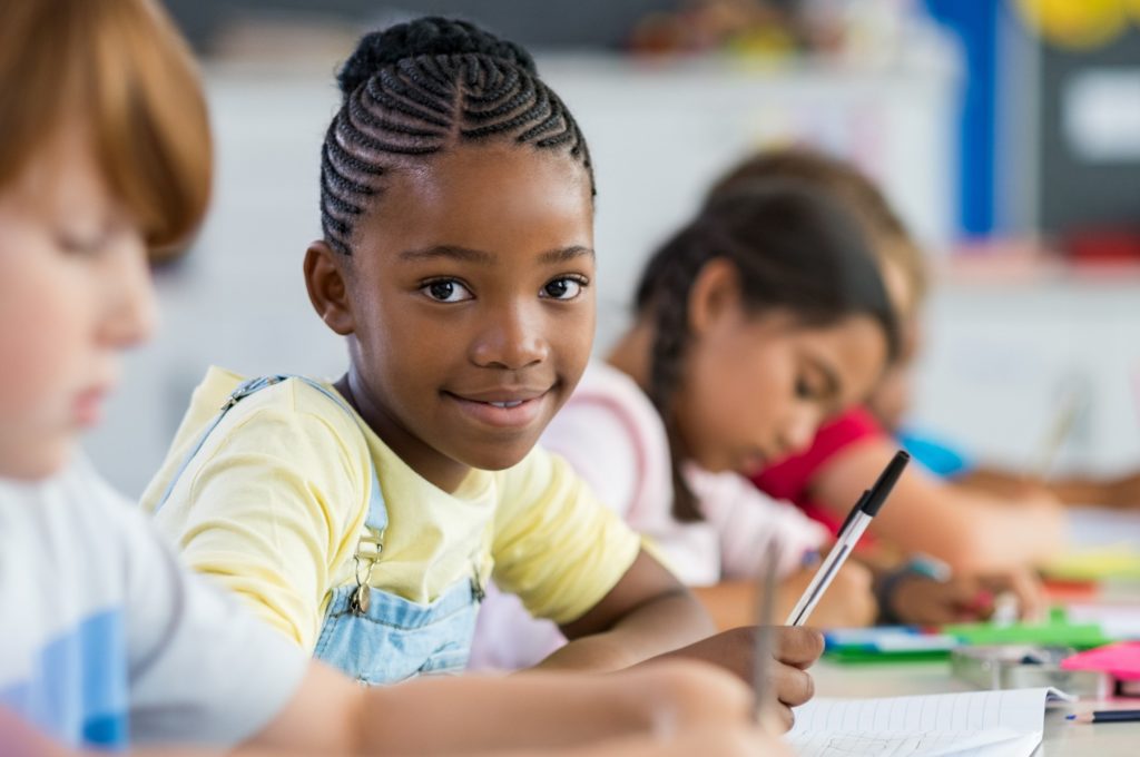 Young girl smiling while working on classwork