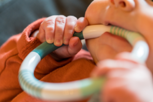 a closeup of a child using a teething ring