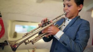 Young boy practicing his trumpet 